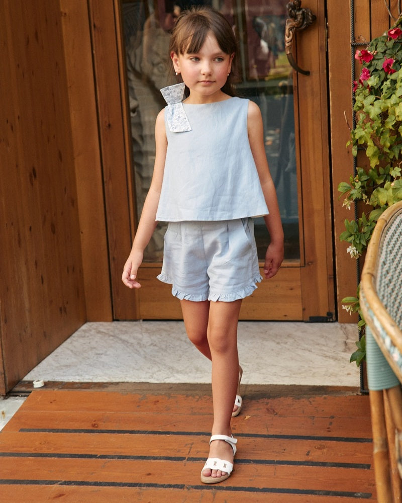 Conjunto de niña azul con lazo de flores y abertura trasera
